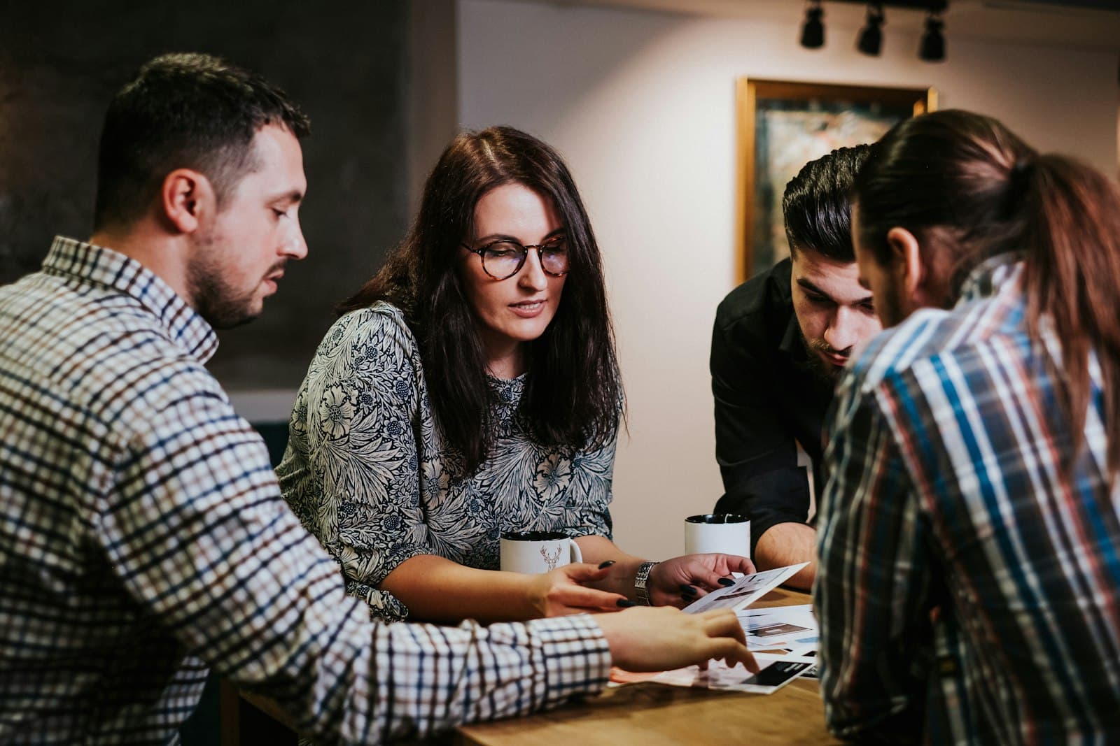 Four people reviewing documents around a table